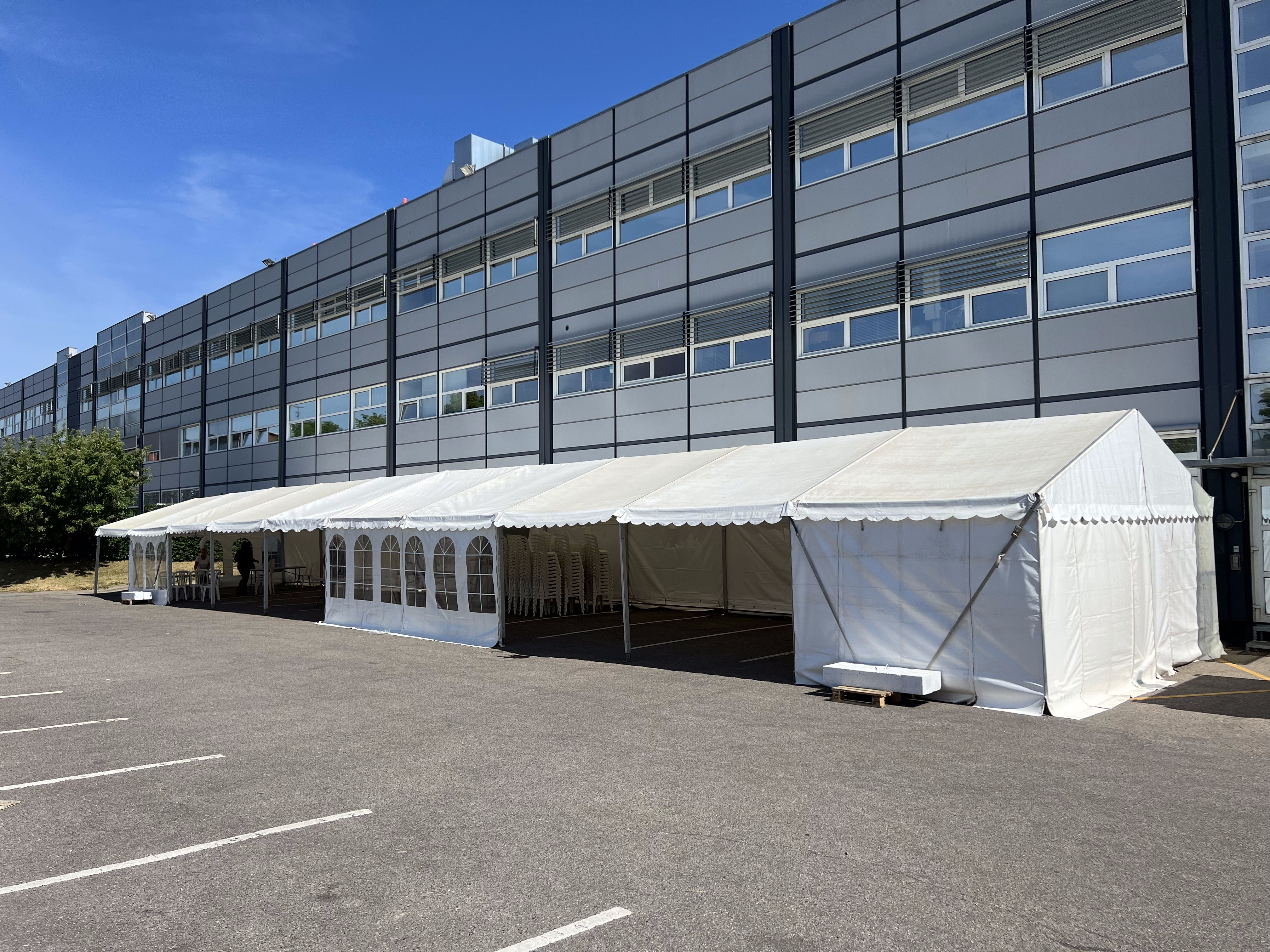 Eight shirts arranged on table in black, olive, grey, blue, white, red, mustard, and green.