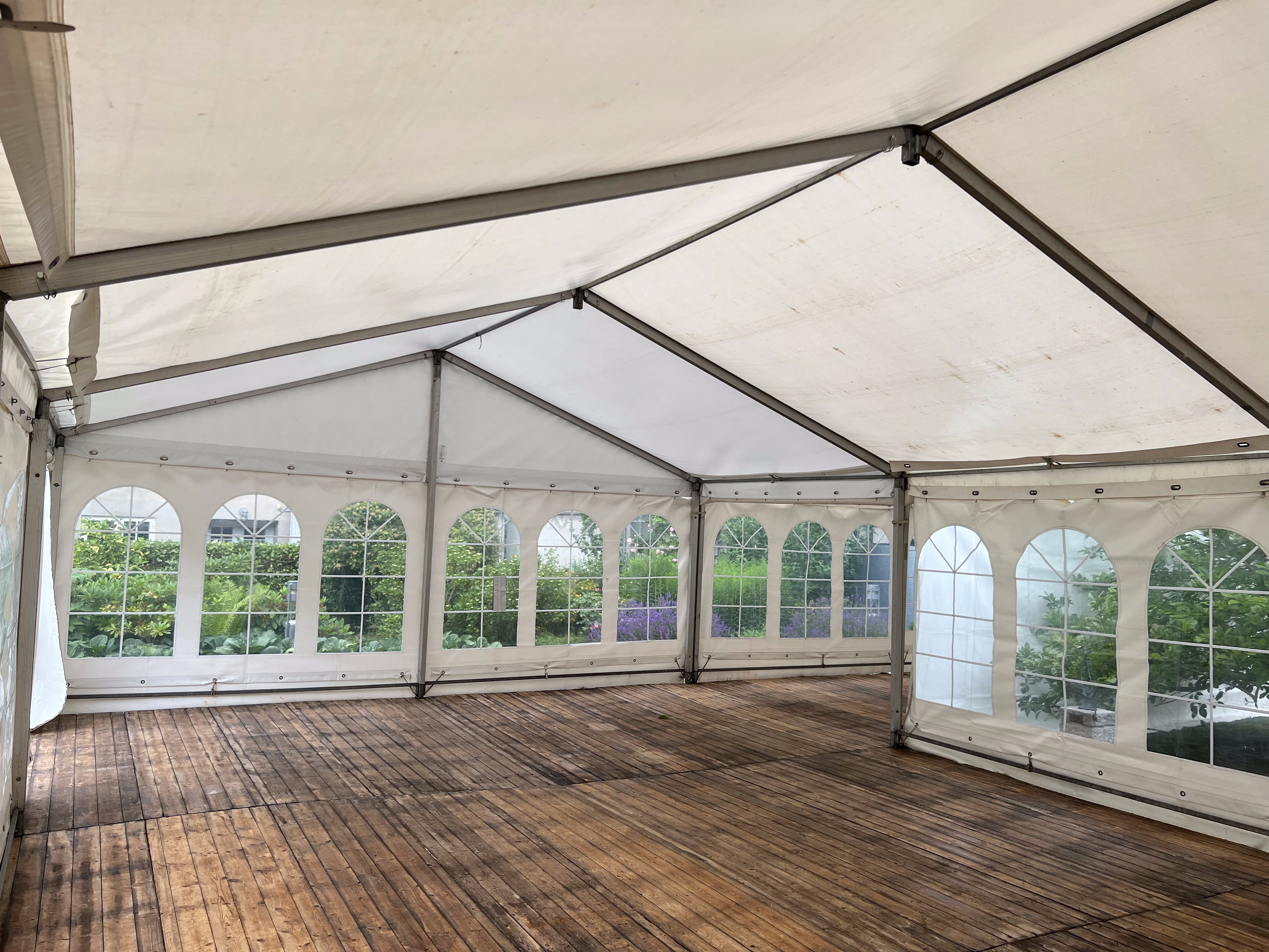 Eight shirts arranged on table in black, olive, grey, blue, white, red, mustard, and green.