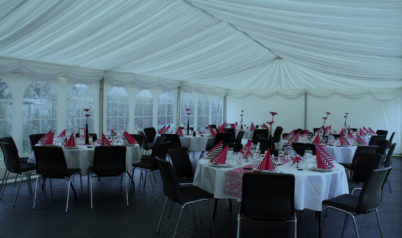 Eight shirts arranged on table in black, olive, grey, blue, white, red, mustard, and green.