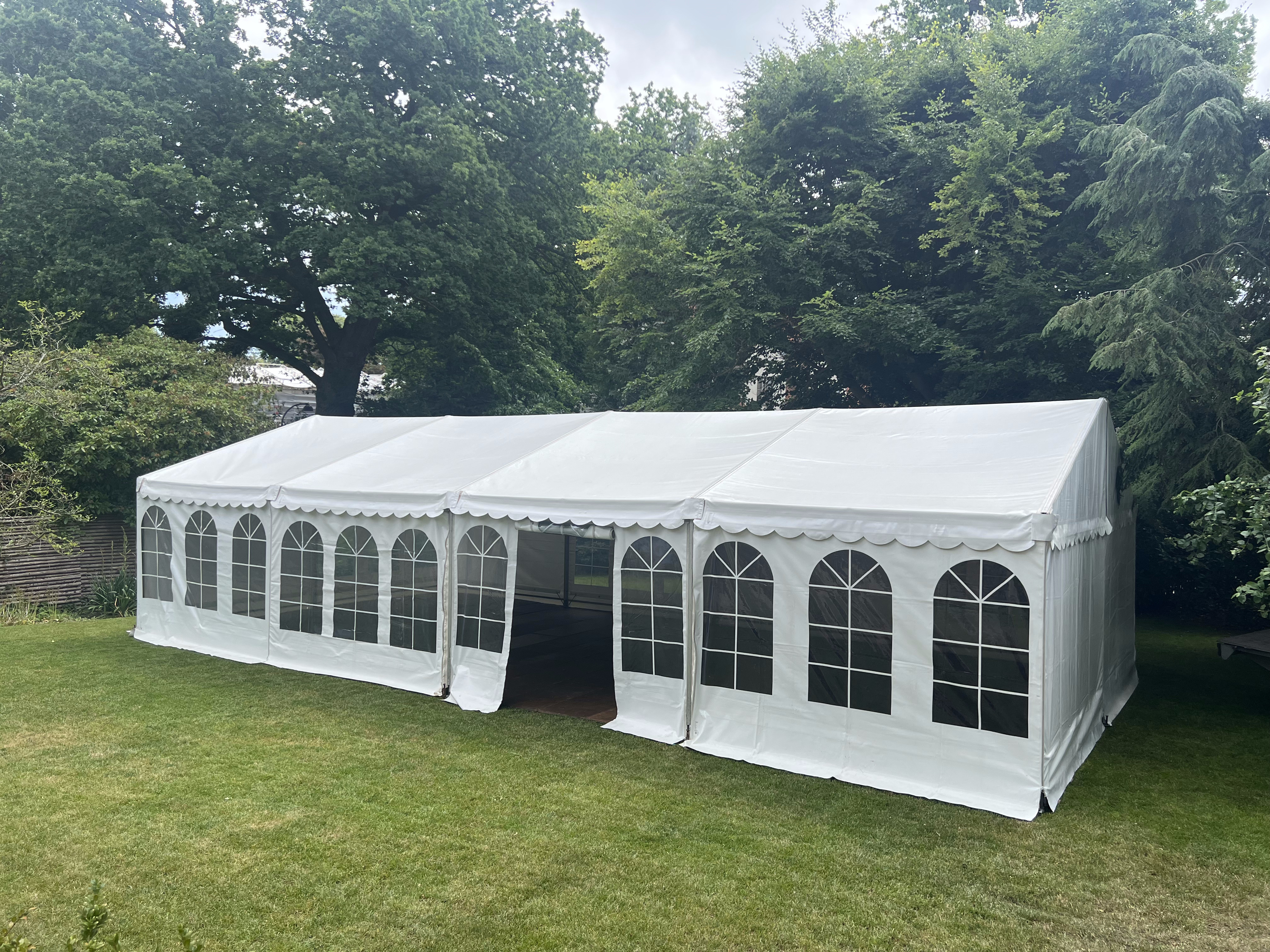 Eight shirts arranged on table in black, olive, grey, blue, white, red, mustard, and green.
