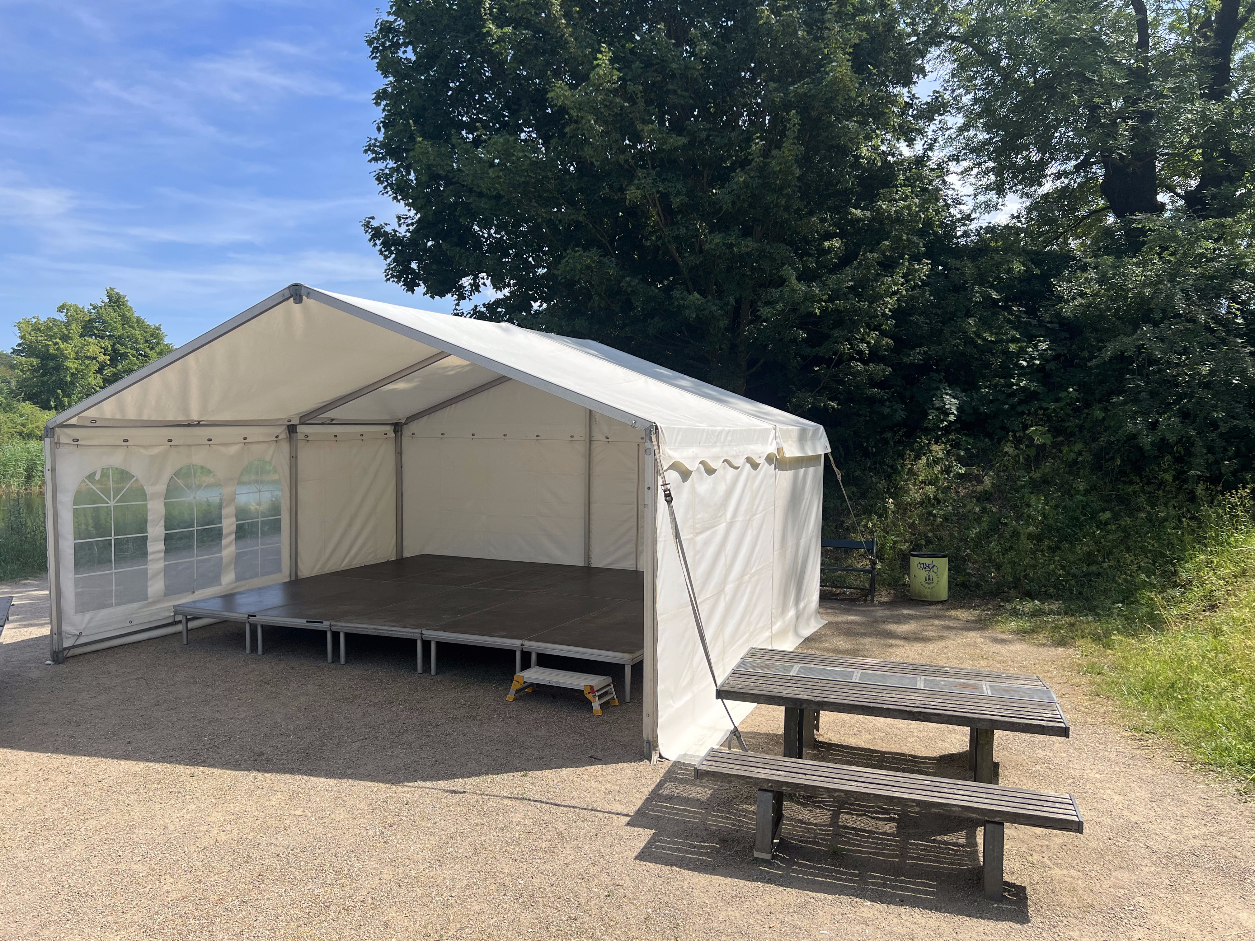 Eight shirts arranged on table in black, olive, grey, blue, white, red, mustard, and green.